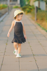 cute girl in dress black and yellow hat her in happy time walking play on ground