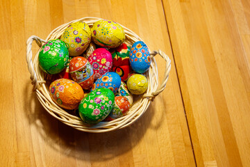 Basket with Easter eggs on wooden table
