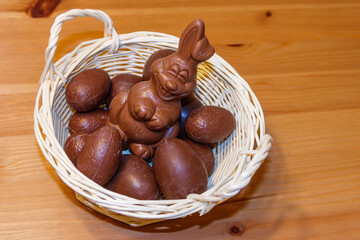 Basket with Easter eggs and Easter bunny on wooden table