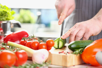 Male chef preparing healthy vegetable salad with fresh organic ingredients