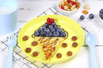 Waffles with fruits for children's breakfast. A creative idea for a fun kids dessert or breakfast
