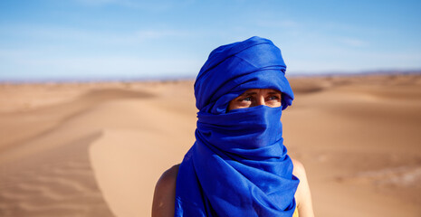 woman tourist with blue turban in the sahara desert - obrazy, fototapety, plakaty