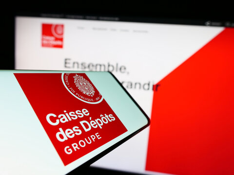 Stuttgart, Germany - 03-12-2023: Cellphone with logo of Caisse des Depots et Consignations (CDC) on screen in front of website. Focus on right of phone display.