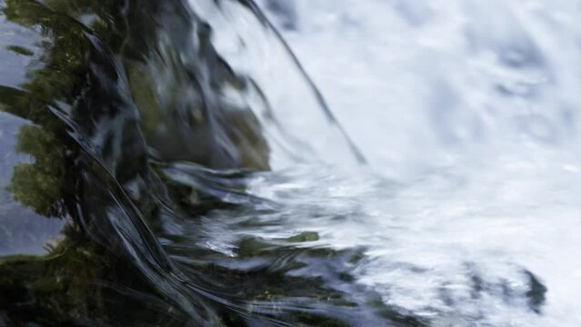 Natural clear spring water flowing on rocks