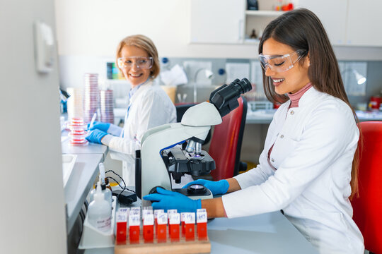 Shot of a Beautiful Female Scientist Looking into the Microscope. Woman Microbiologist Working on Molecule Samples in Modern Laboratory with Technological Equipment.