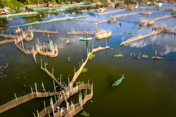 A man is setting up a fishing net on a lake in Bao Loc Town, Lam Dong Province, Vietnam
