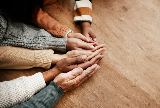 People, hands together and generations in care above on mockup for unity, compassion or trust on wooden table. Group holding hand for support collaboration, love or community in teamwork solidarity