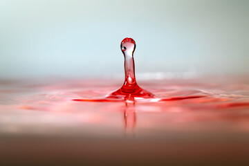 Moment of water drops colliding on pink background. Abstract natural background