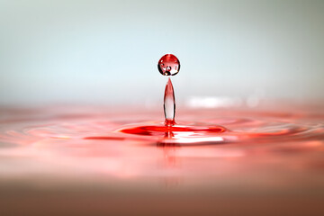 Moment of water drops colliding on pink background. Abstract natural background