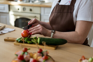 Cooking in the kitchen diet menu, healthy food, ready snacks delivery concept. Hands of the chef in the frame cutting vegetables