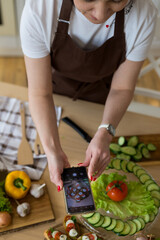 Cooking in the kitchen diet menu, healthy food, ready snacks. The hands of the chef in the frame take a photo of ready meals and table setting