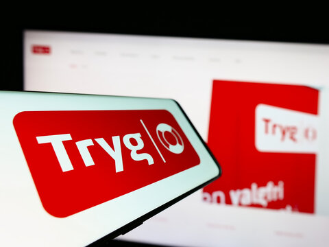 Stuttgart, Germany - 03-12-2023: Mobile phone with logo of Danish insurance company Tryg Forsikring AS on screen in front of business website. Focus on center of phone display.