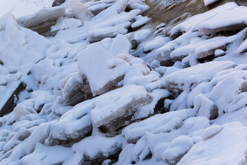 Huge broken ice floes lie on the river bank. Texture. Background.