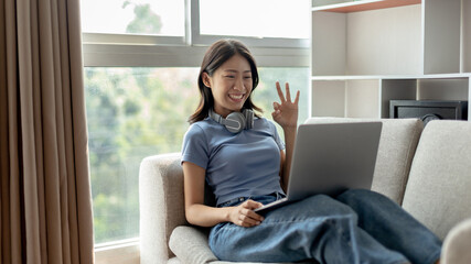 Young Asian woman greets his friends and teachers in a live video with a smile on his face, Online communication , Stay home, New normal, VDO Call, Social distancing, Internet learning.
