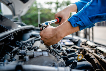 Close up of view Auto mechanic repairman using a socket wrench working engine repair in the garage,...