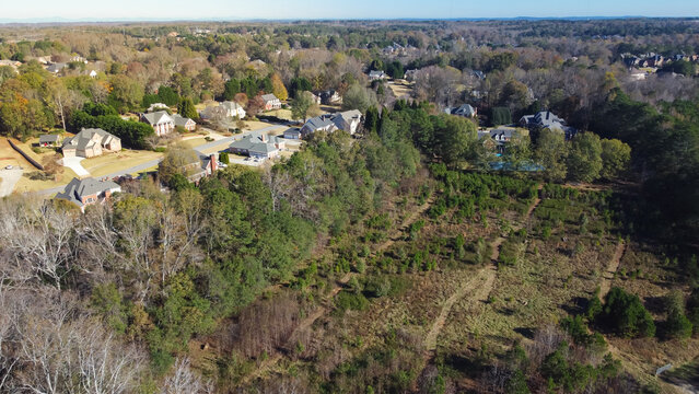 Low density housing residential area with Chestnut Mountain in distance background, row of upscale multistory single-family homes in Flowery Branch, Georgia, USA