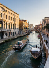Fototapeta na wymiar Canal in Venice, Italy and boat navigating passing by