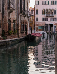 Boat docked in a canal in Venice, Italy, and charming traditional architecture. 