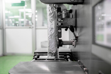 Close up of view Manufacture process automatic fill powder machine vertical sealing with packing sachet foil in the supplement product line.