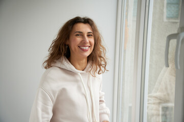 Portrait of happy smiling female relaxing at home looking straight into the camera. Attractive ...