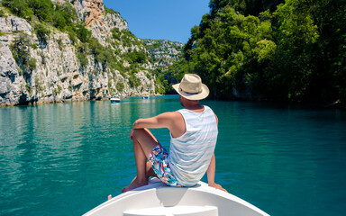 Young men in front of a boat at Gorges Du Verdon lake of Sainte Croix, Provence, France, Provence...