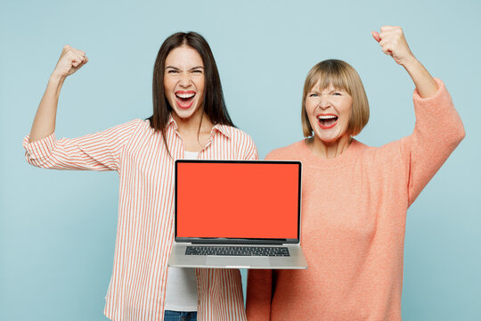 Winner Elder Parent Mom With Young Adult Daughter Two IT Women Together Wears Casual Clothes Work Hold Use Laptop Pc Computer Blank Screen Area Isolated On Plain Blue Background. Family Day Concept.