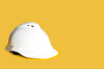 Engineer white helmet on yellow background. Safety construction