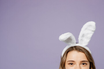 Cropped close up photo shot of young caucasian woman wear bunny rabbit ears loking camera isolated on plain pastel light purple violet color background studio portrait. Lifestyle Happy Easter concept.