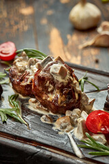 Beef medallions with mushroom sauce on a wooden board with spices. Close-up