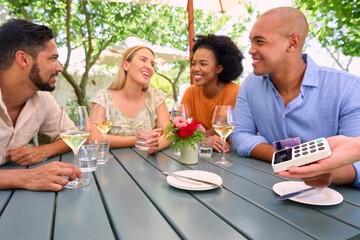 Man Making Contactless Payment At Outdoor Bar Or Restaurant Using Credit Or Debit Card