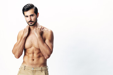 Fototapeta premium Man athlete model with a naked torso and six pack abs sporty inflated figure and tan on a white isolated background, fashionable clothing style, copy space, space for text