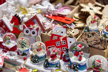 Fototapeta na wymiar European Christmas market stall in Old Town. colorful Christmas ornaments are some of the most popular souvenirs with tourists at seasonal fairs.