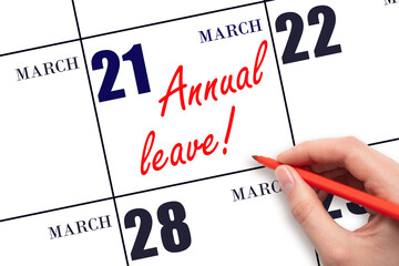 Hand writing the text ANNUAL LEAVE and drawing the sun on the calendar date March 21