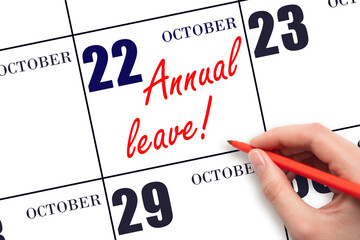 Hand writing the text ANNUAL LEAVE and drawing the sun on the calendar date October 22