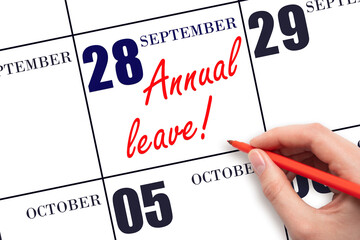 Hand writing the text ANNUAL LEAVE and drawing the sun on the calendar date September  28