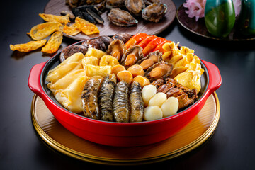 traditional giant hot pot Peng cai with dry seafood abalone sea cucumber crab prawn meat scallop oyster mushroom with thick brown sauce in red claypot asian Chinese new year luxury hotel menu