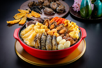 traditional giant hot pot Peng cai with dry seafood abalone sea cucumber crab prawn meat scallop oyster mushroom with thick brown sauce in red claypot asian Chinese new year luxury hotel menu