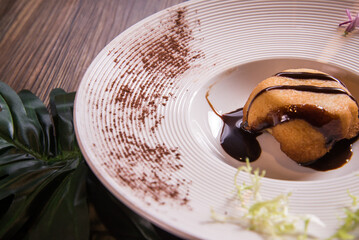 hot deep fried cold vanilla ice cream in bread with chocolate sauce in white plate on wood table asian cafe sweet dessert halal food restaurant menu