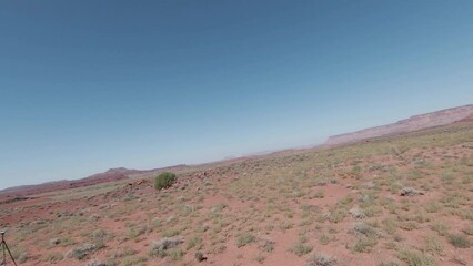 Experience the thrill of aerial FPV motion as it explores the breathtaking Indian Creek desert on a sunny day.