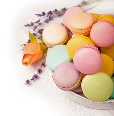 Many delicious colorful macarons in box on white background