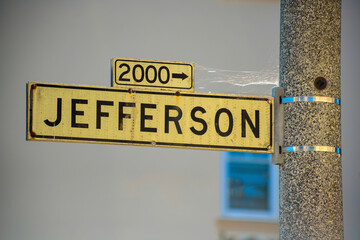 Black and white road sign on street lamp that say Jefferson in historic districts of downtown san francisco california