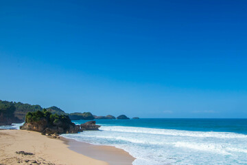 Tropical rocky beach with white sand and cliffs and blue sky with clouds on Sunny day. Summer tropical landscape, panoramic view. travel tourism wide panorama background concept. 