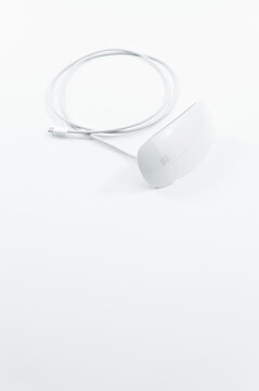 immagine di periferica Bluetooth Apple Magic Mouse con cavo ricarica su superficie bianca