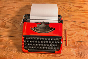 Vintage mechanical typewriter, red wooden background