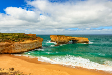 Sea view London Arch remains of formerly known as London Bridge a natural arch in the Port Campbell National Park, Victoria Australia with teal sparkling sea water and blue sky with cloudy