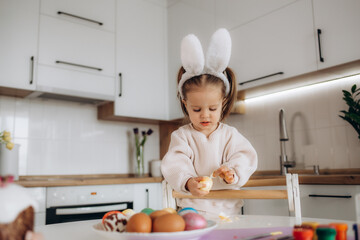 a little cute girl paints Easter eggs. spring flowers hyacinths, colorful eggs - holiday decoration.