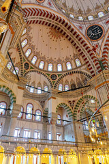 Fototapeta na wymiar Interior of Fatih Mosque, Ottoman mosque in the Fatih district of Istanbul, with a huge decorated domes. Arabic text as decor (verses from Koran, muslim Holy book). Istanbul, Turkey