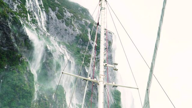 Water falling from mountain slopes during heavy rainfall in Milford Sound, view from ship