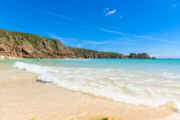 Porthcurno beach, picturesque retreat featuring turquoise waters, surrounding granite cliffs and golden sand. Cornwall, England UK