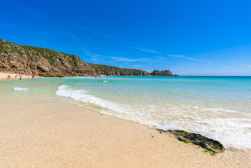Fototapeta na wymiar Porthcurno beach, picturesque retreat featuring turquoise waters, surrounding granite cliffs and golden sand. Cornwall, England UK
